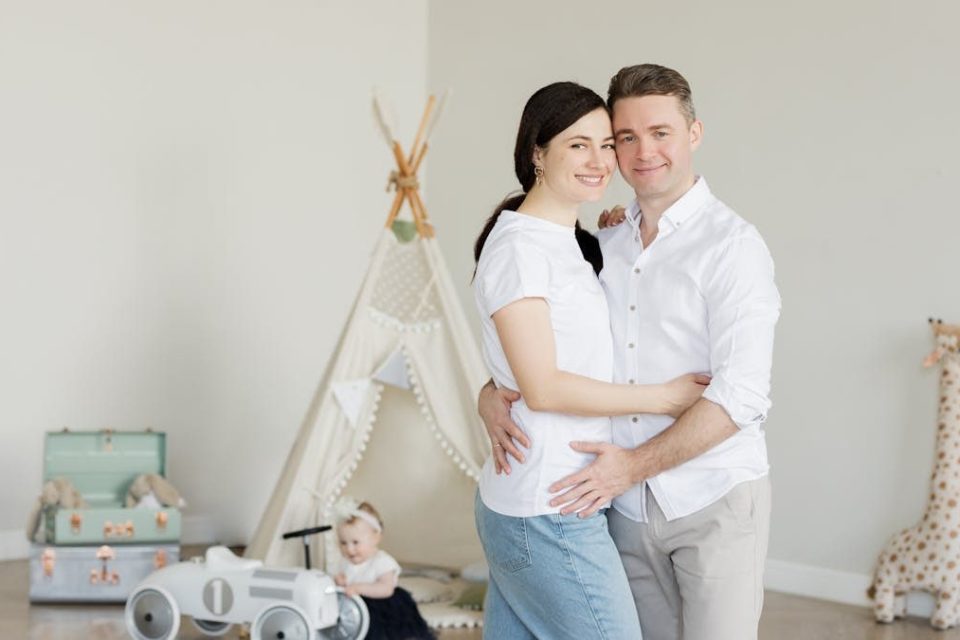 A joyful family with a toddler in a cozy room with playful decor and a teepee.